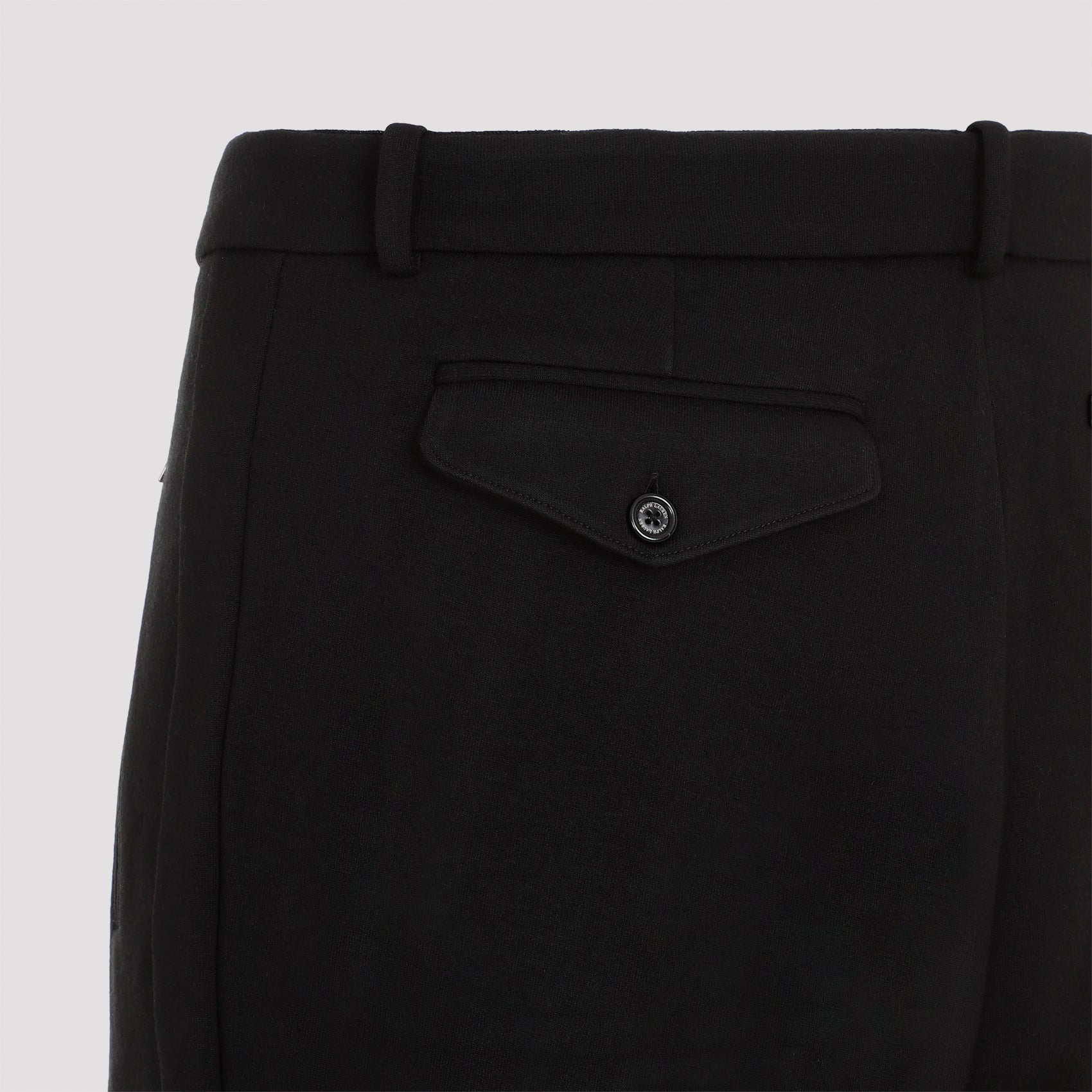 Black wool jogger pants showing belt loops and fly-zip closure by Ralph Lauren Purple Label, waist detail