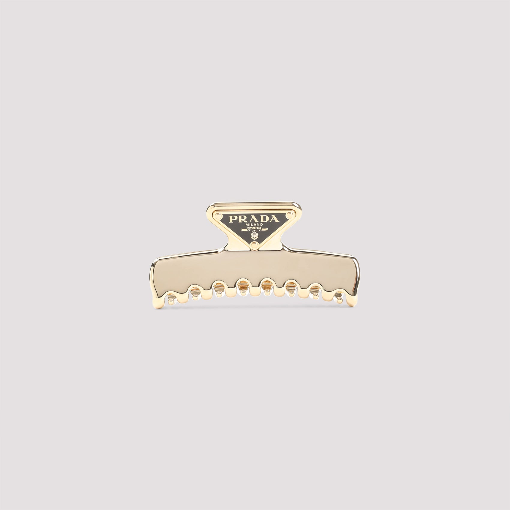 Gold Prada metal hair clip with enameled triangle logo, front view