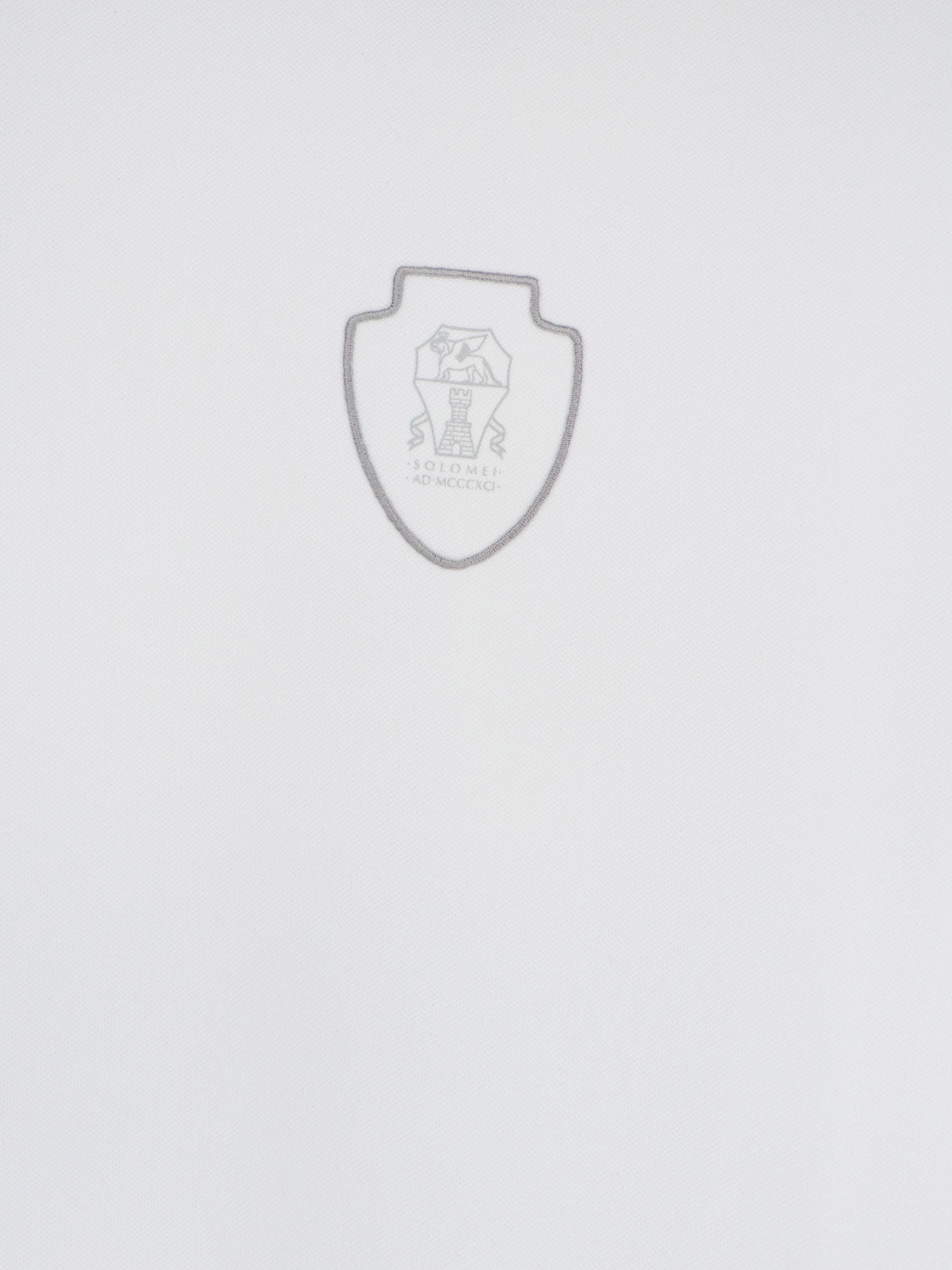 White technical polo shirt by Brunello Cucinelli showing embroidered logo, close-up