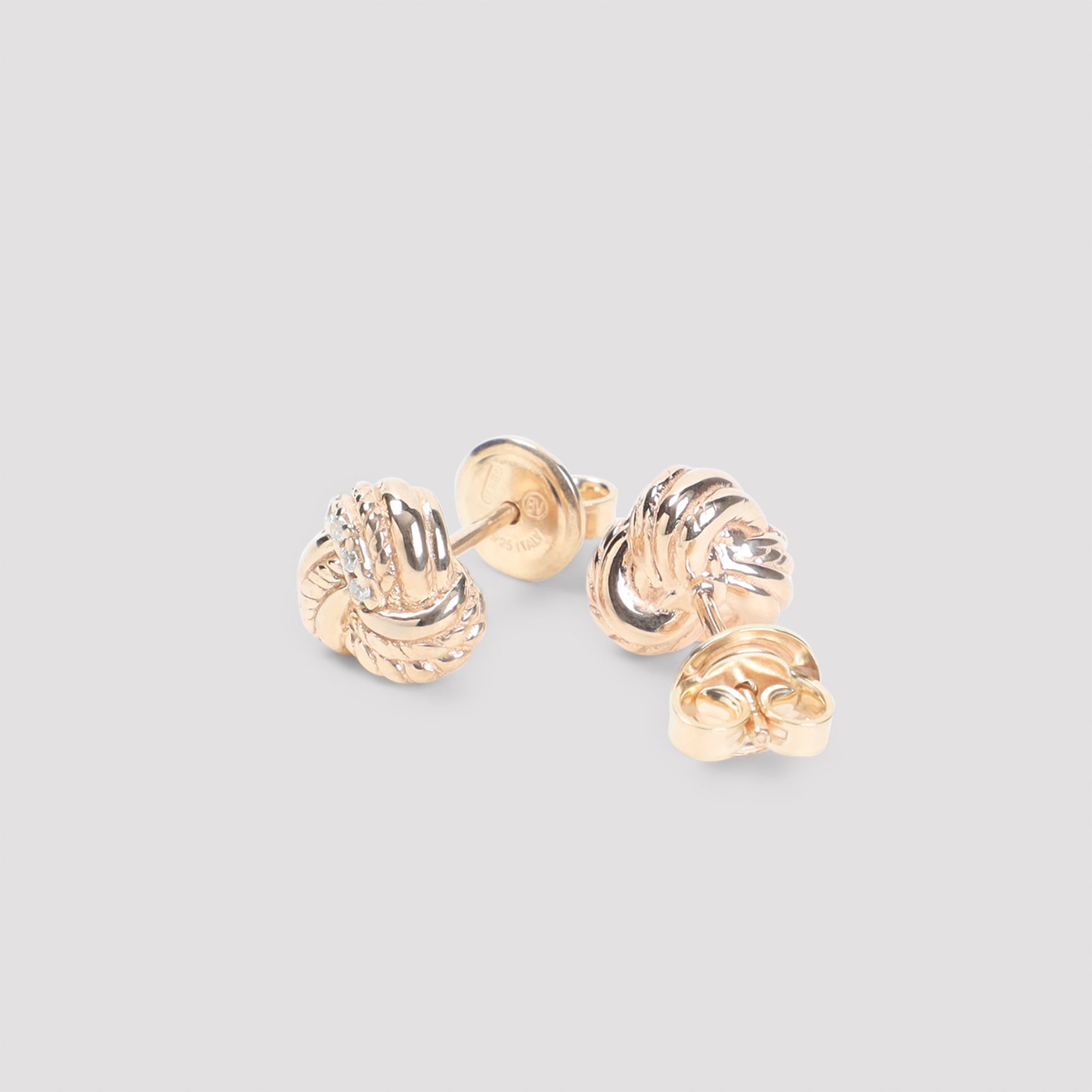 White Bottega Veneta knotted stud earrings showing crystal embellishment detail
