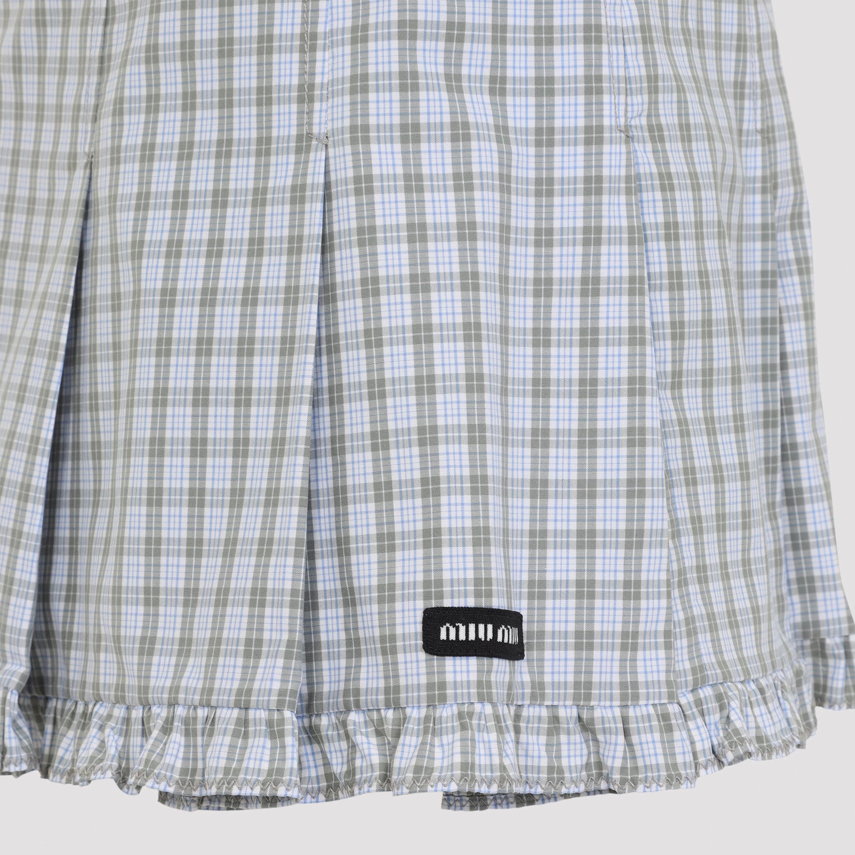 Miu Miu mini skirt in white checked cotton, close-up of logo patch
