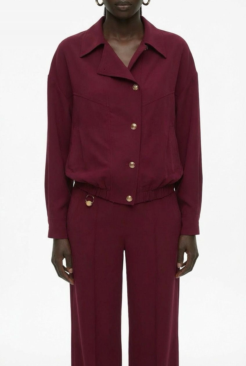 Burgundy bomber jacket detail view showing smooth fluid fabric and seam construction