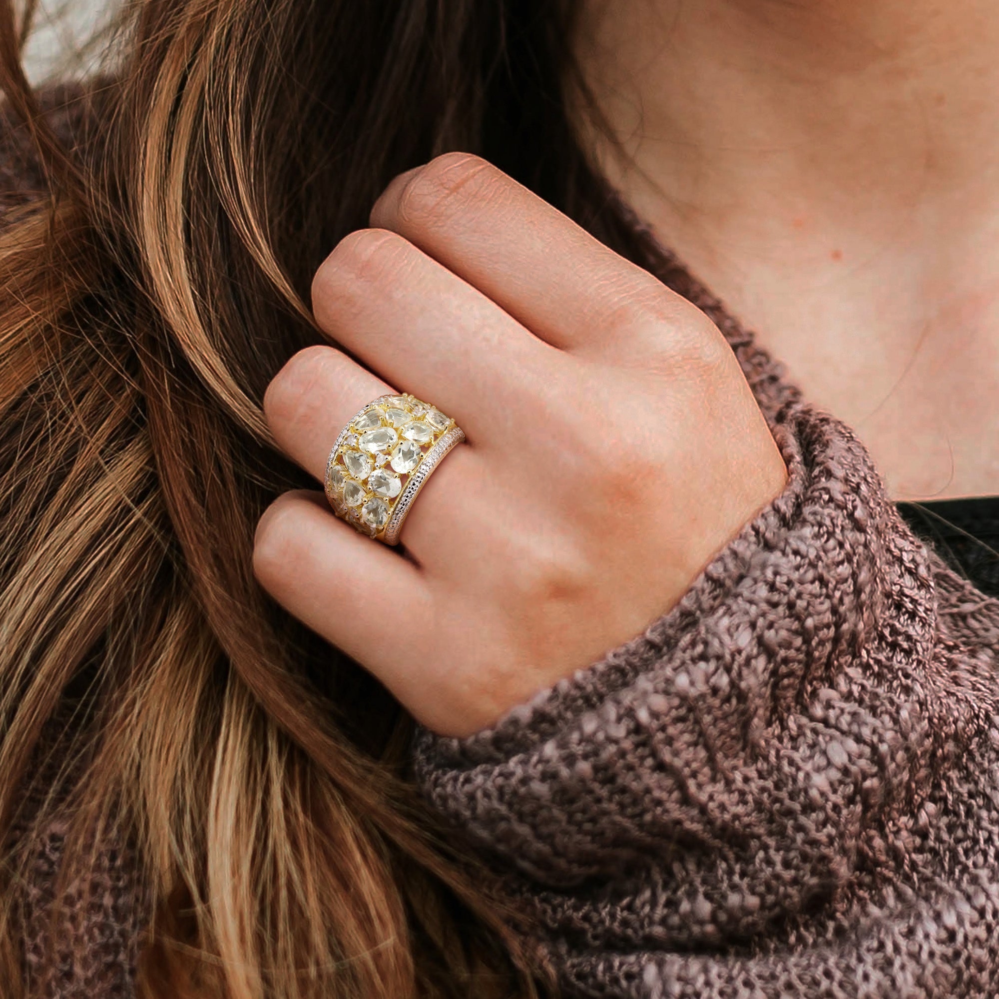 Green quartz gemstone cocktail ring with yellow-tone plating worn on hand