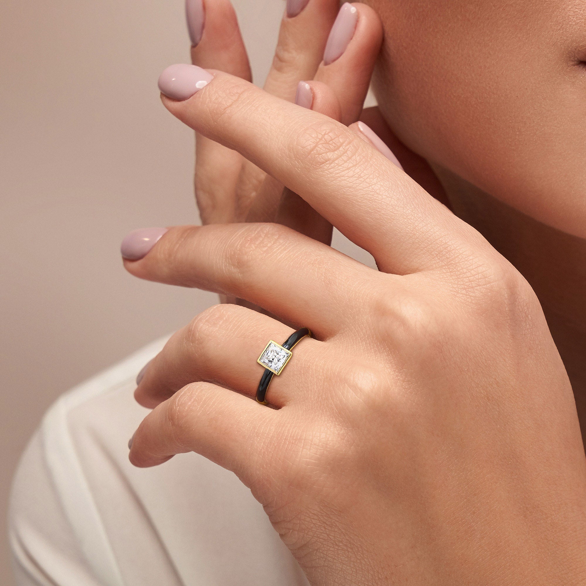 Yellow gold plated moissanite solitaire ring with black enamel band worn on hand by Lord & Taylor