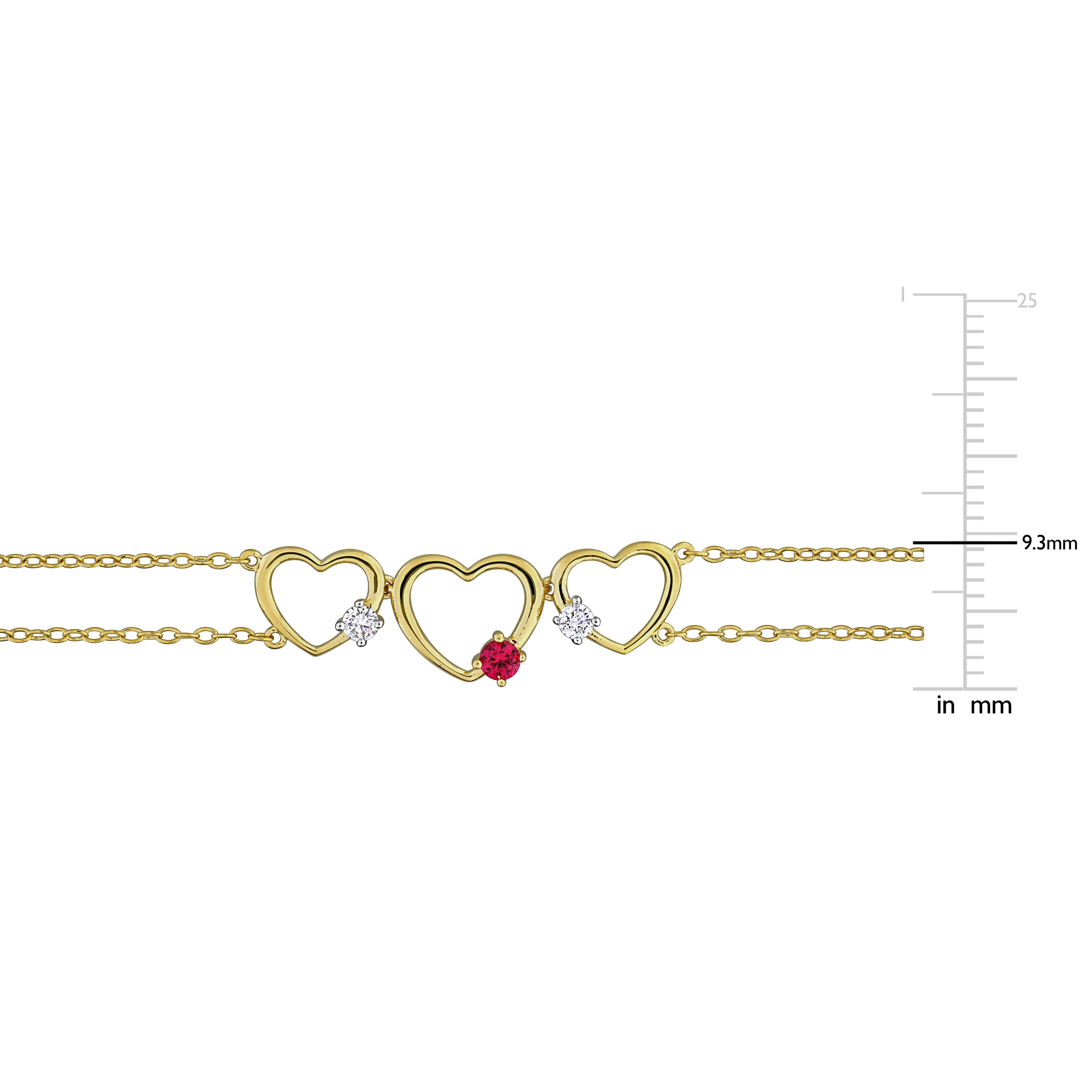 Close-up of heart-shaped created ruby with round diamond accents in yellow-plated sterling silver