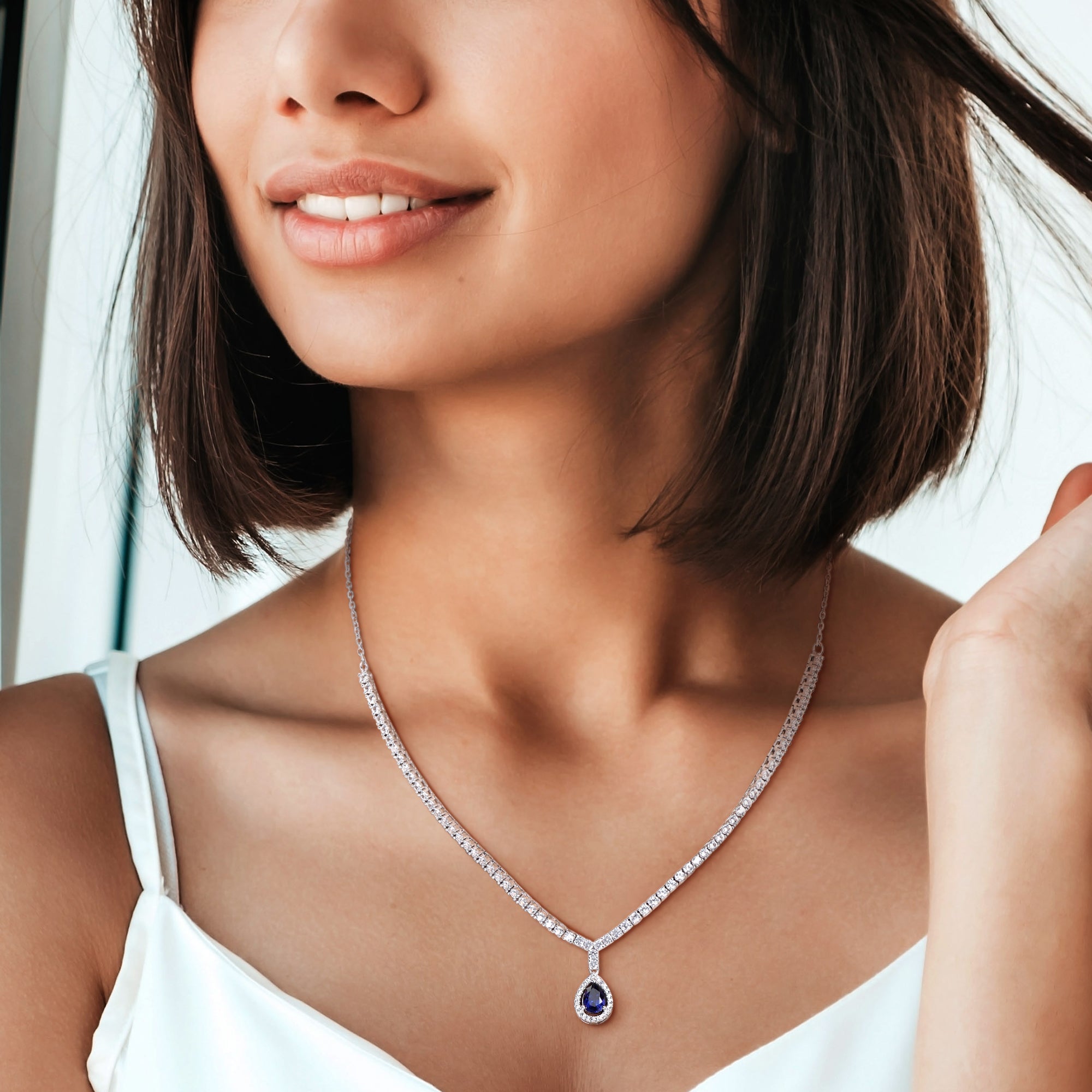 Blue sapphire tennis necklace by Lord & Taylor worn on model, showing drape and pendant placement