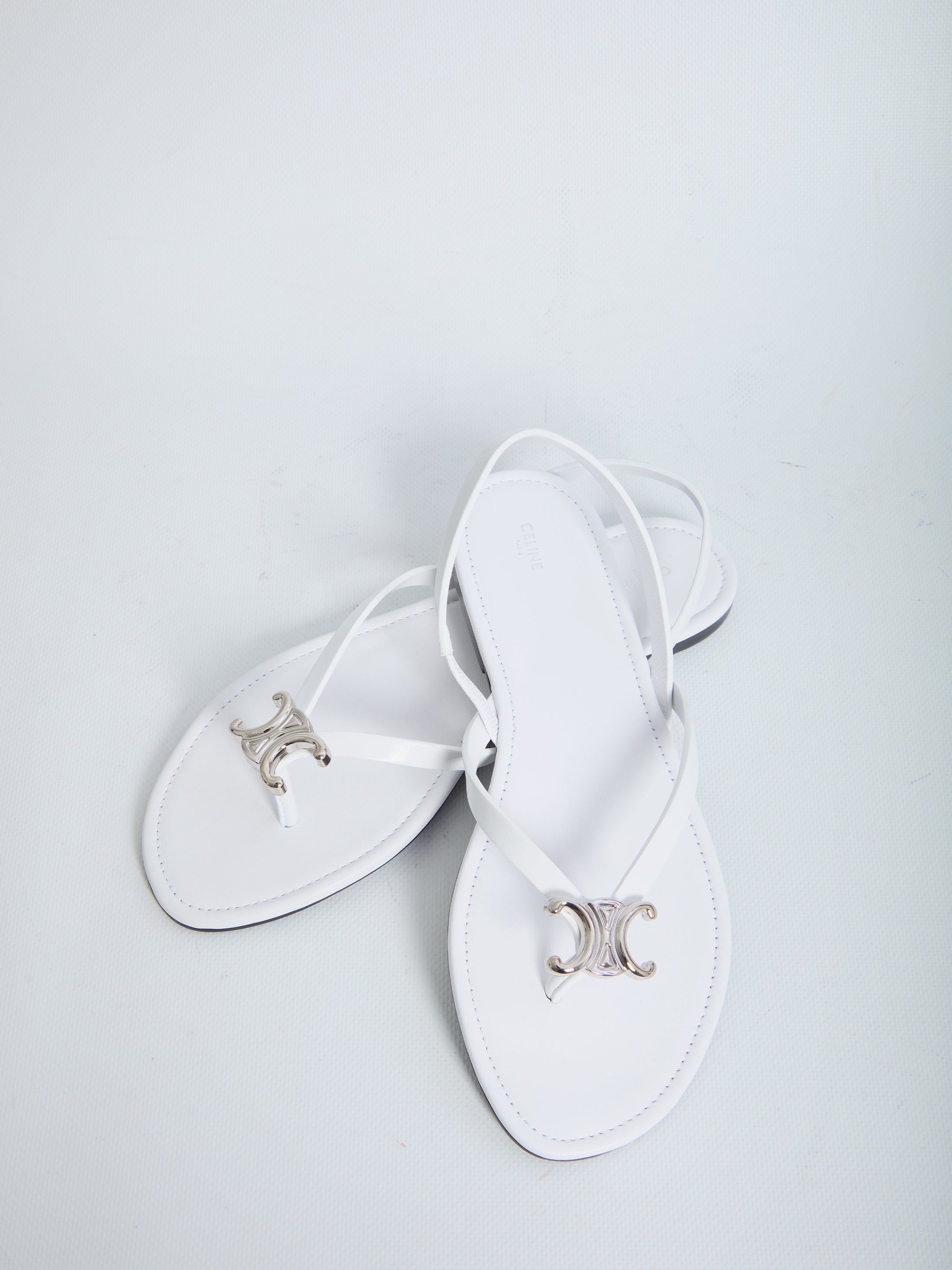 White calf leather slider sandals by Celine showing leather sole, bottom view