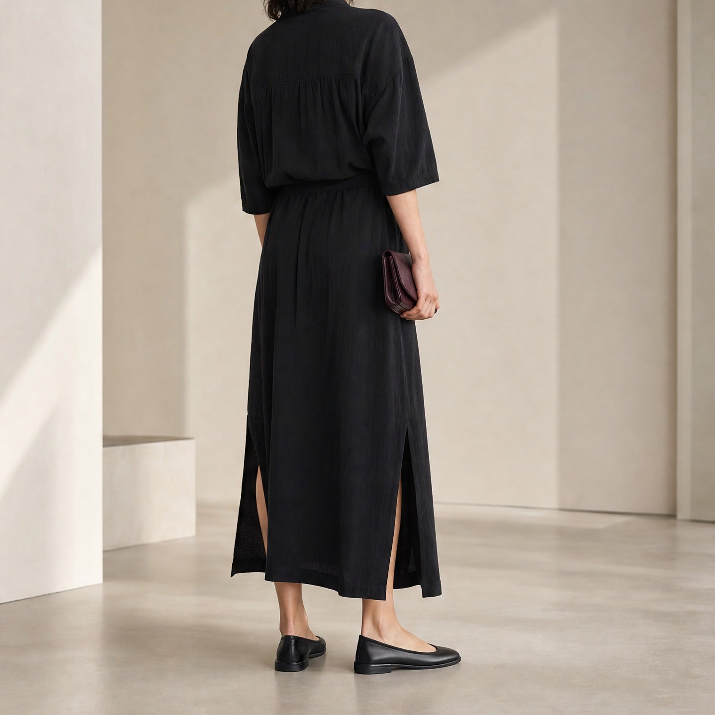 Black Lemaire asymmetrical dress hemline detail, close-up back