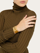Tan leather wide cuff bracelet by Salvatore Ferragamo, side angle view