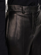 Black leather trousers by Salvatore Ferragamo, detail of waist and zip-fly closure