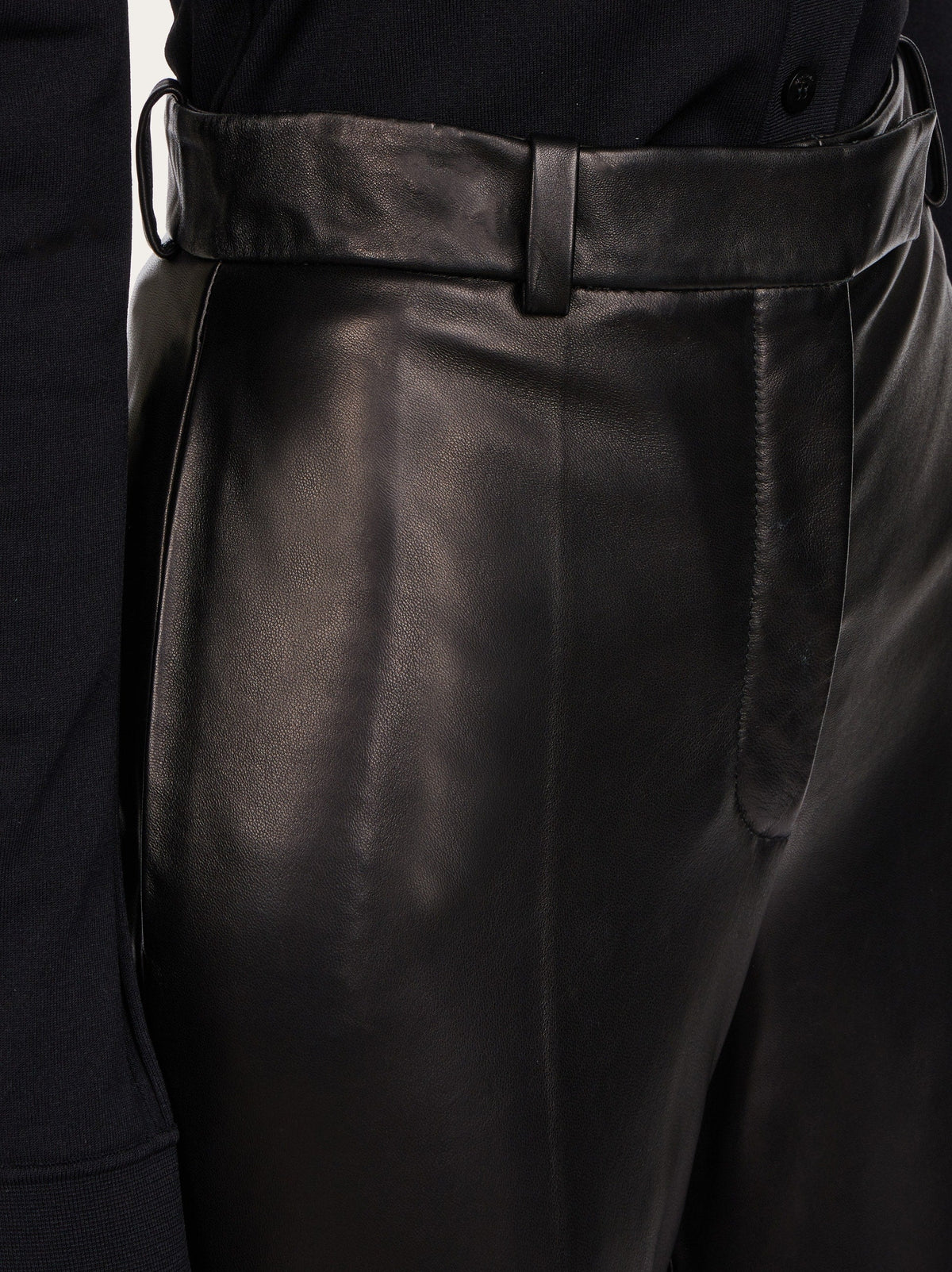 Black leather trousers by Salvatore Ferragamo, detail of waist and zip-fly closure