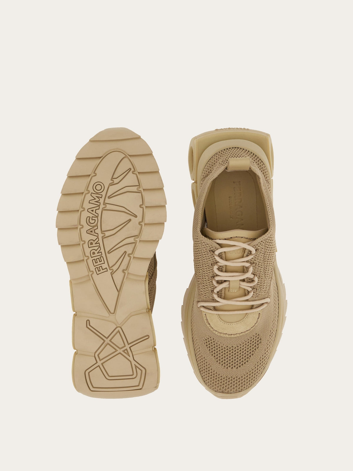 Salvatore Ferragamo beige sneaker detail showing embossed Gancini plaque at tongue