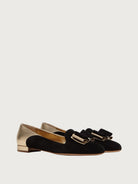 Black suede Salvatore Ferragamo ballet flat with gold bow hardware, front angle