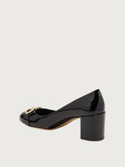 Close-up of gold-tone Gancini ornament on black patent leather Ferragamo Garda pump