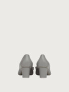 Salvatore Ferragamo grey leather pump showing logo hardware on bow, detail view