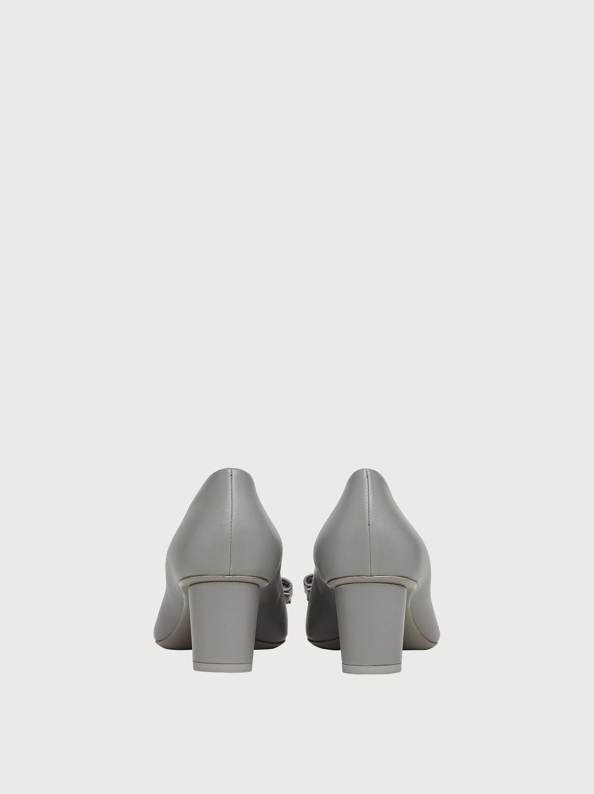Salvatore Ferragamo grey leather pump showing logo hardware on bow, detail view