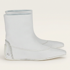 White Salvatore Ferragamo leather bootie showing curved seam detail, angled view