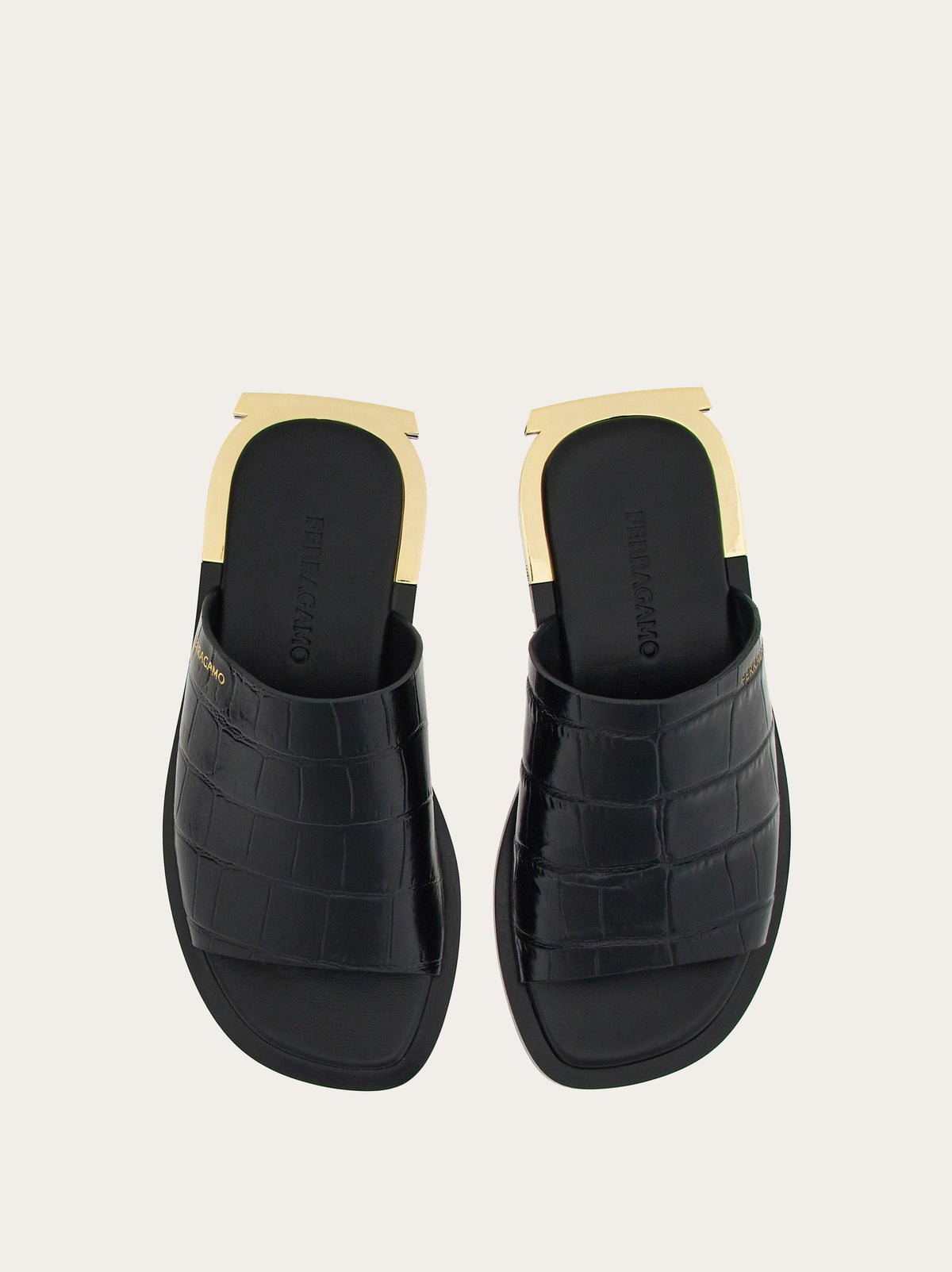 Black Salvatore Ferragamo slide sandals with gold Gancio detail, top view