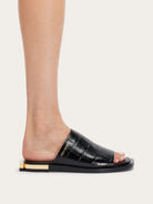 Black calfskin Ferragamo slides showing sculptural Gancio heel, rear view