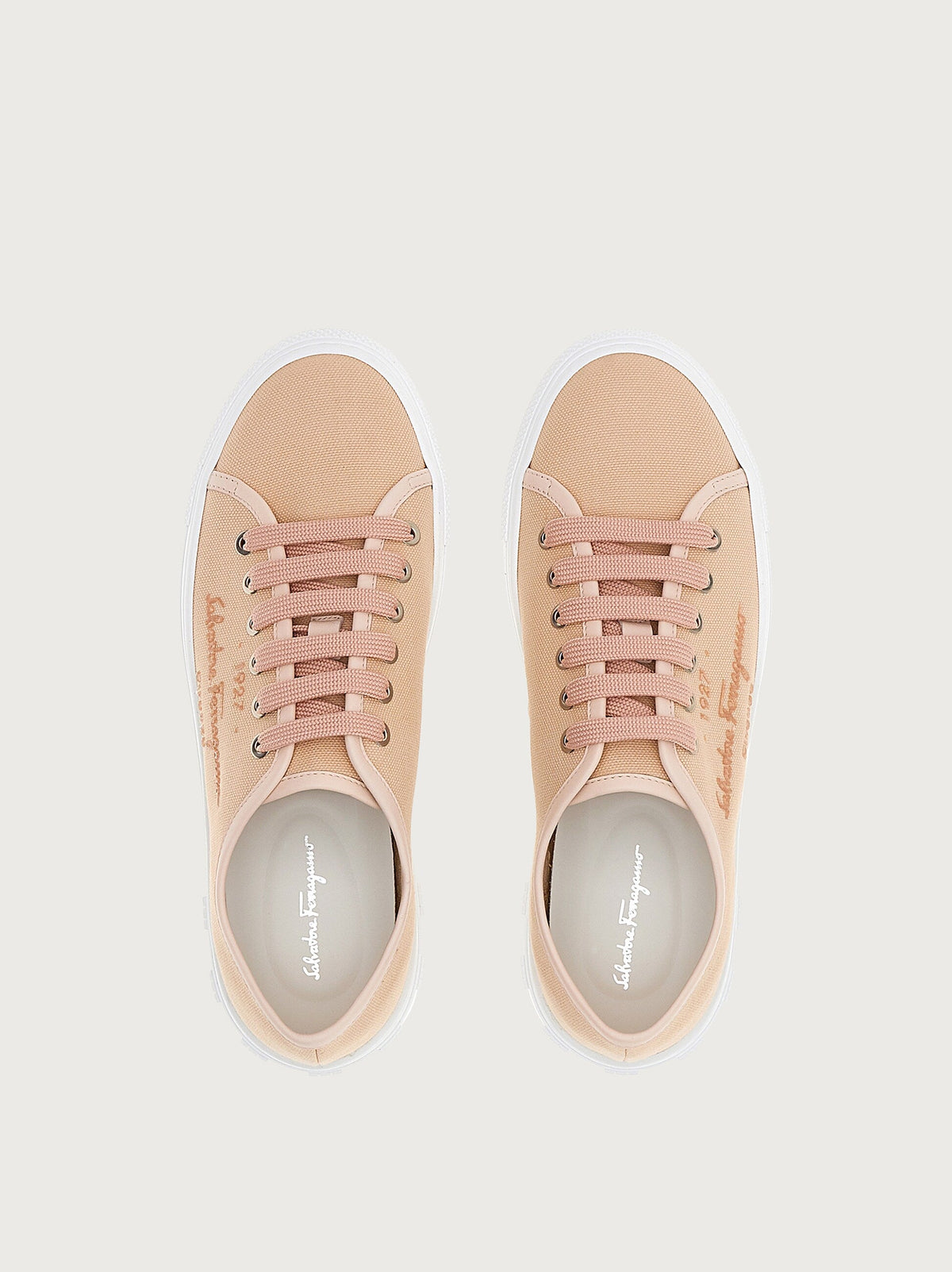 Light pink Salvatore Ferragamo sneaker with gold-tone eyelets, front angle