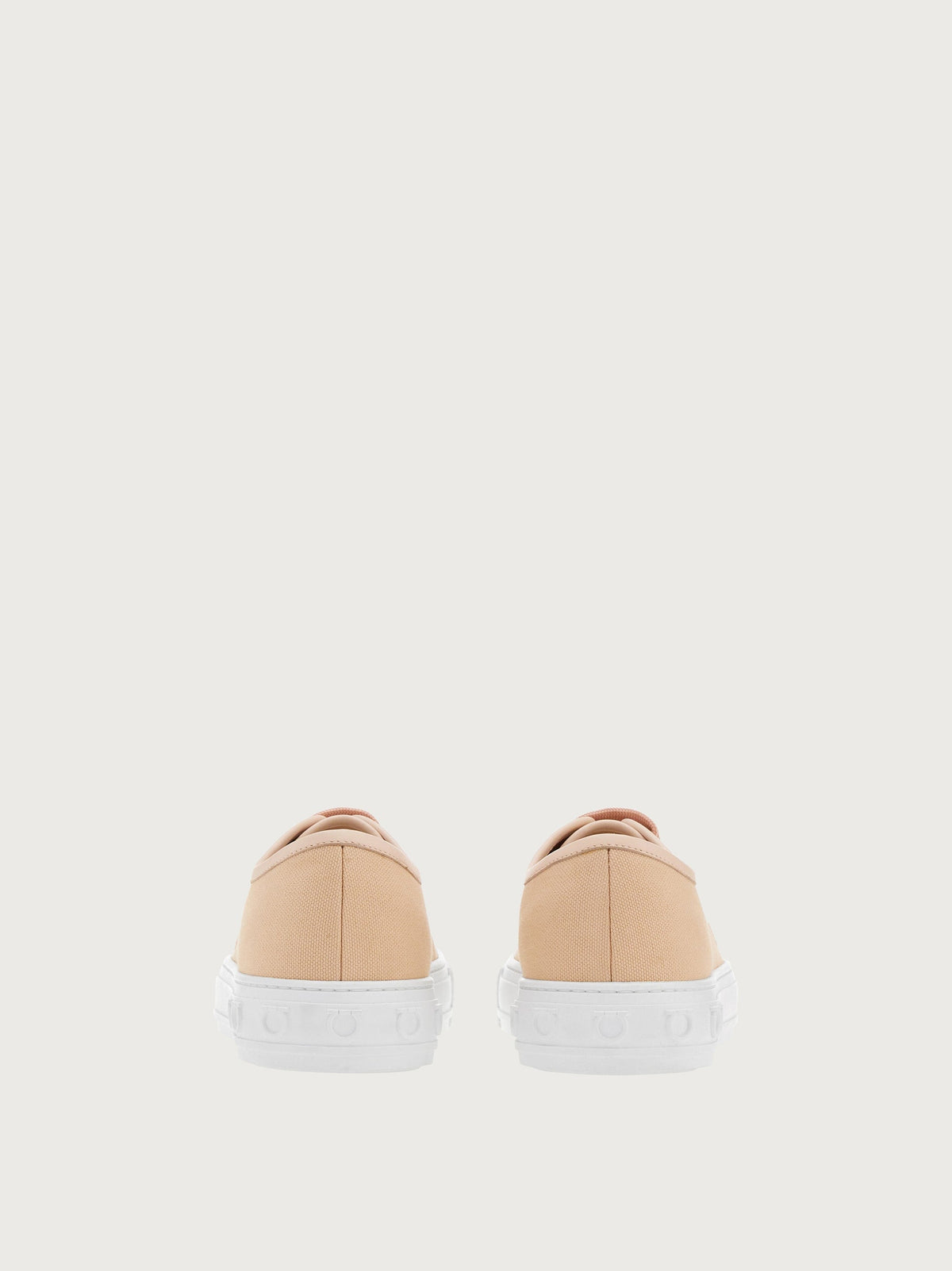 Light pink Ferragamo sneaker rear view with embossed Gancini motif
