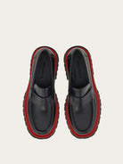 Black Salvatore Ferragamo Fergal loafer showing red midsole detail, angled view