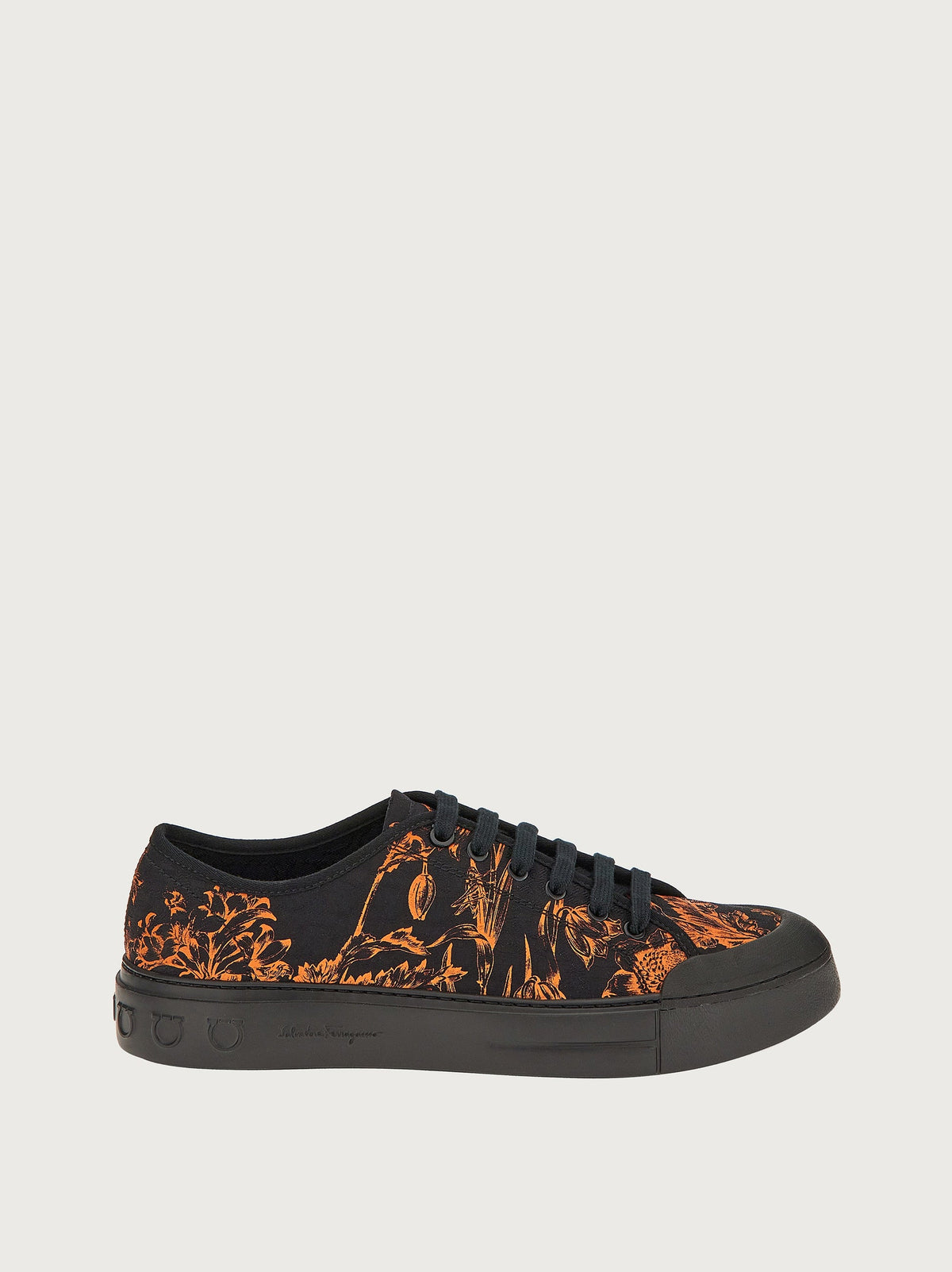 Black canvas sneaker with orange botanical print by Salvatore Ferragamo, side view