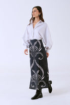 Black cotton poplin midi skirt by Beyond by Vera, side angle showing fitted silhouette