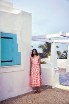 White sleeveless dress with palm tree print, close-up of ruffle detail