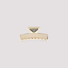 Gold Prada metal hair clip with enameled triangle logo, front view