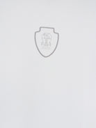 White technical polo shirt by Brunello Cucinelli showing embroidered logo, close-up