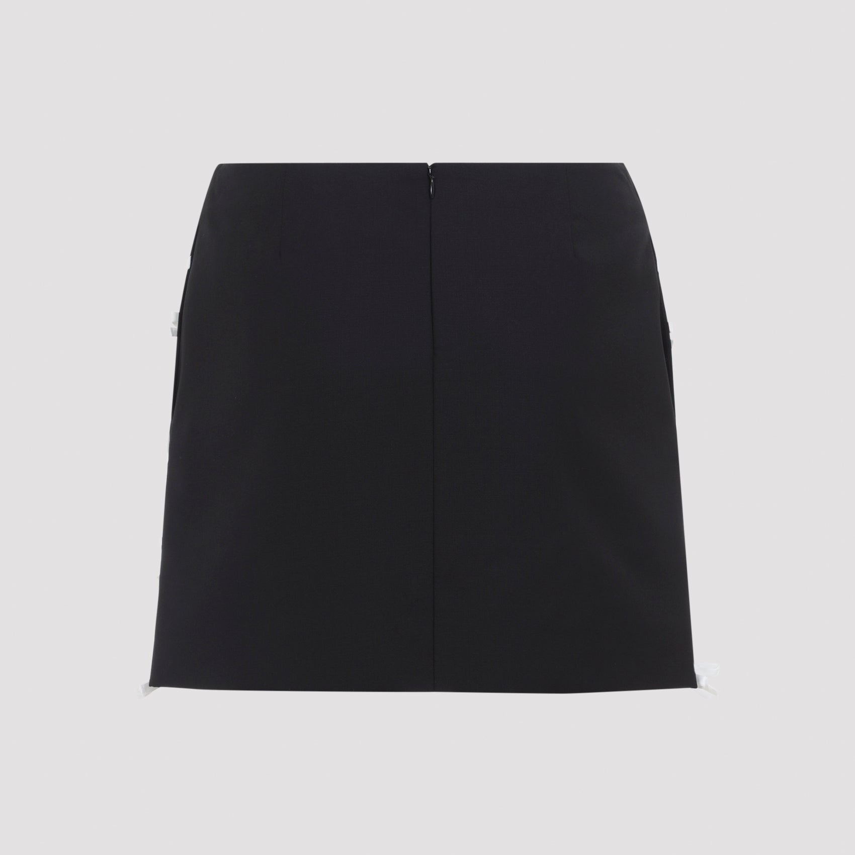Black Moschino virgin wool mini skirt showing bow appliqué detail, close-up