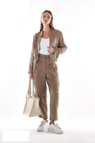 Beige metallic trousers styled with coordinating bomber jacket, full outfit view