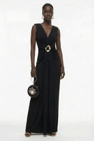 Black matte jersey gown styled with floral clutch and metallic heels by Lord & Taylor Heritage