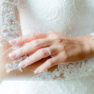 Sterling silver three-stone moissanite ring worn on hand by Lord & Taylor
