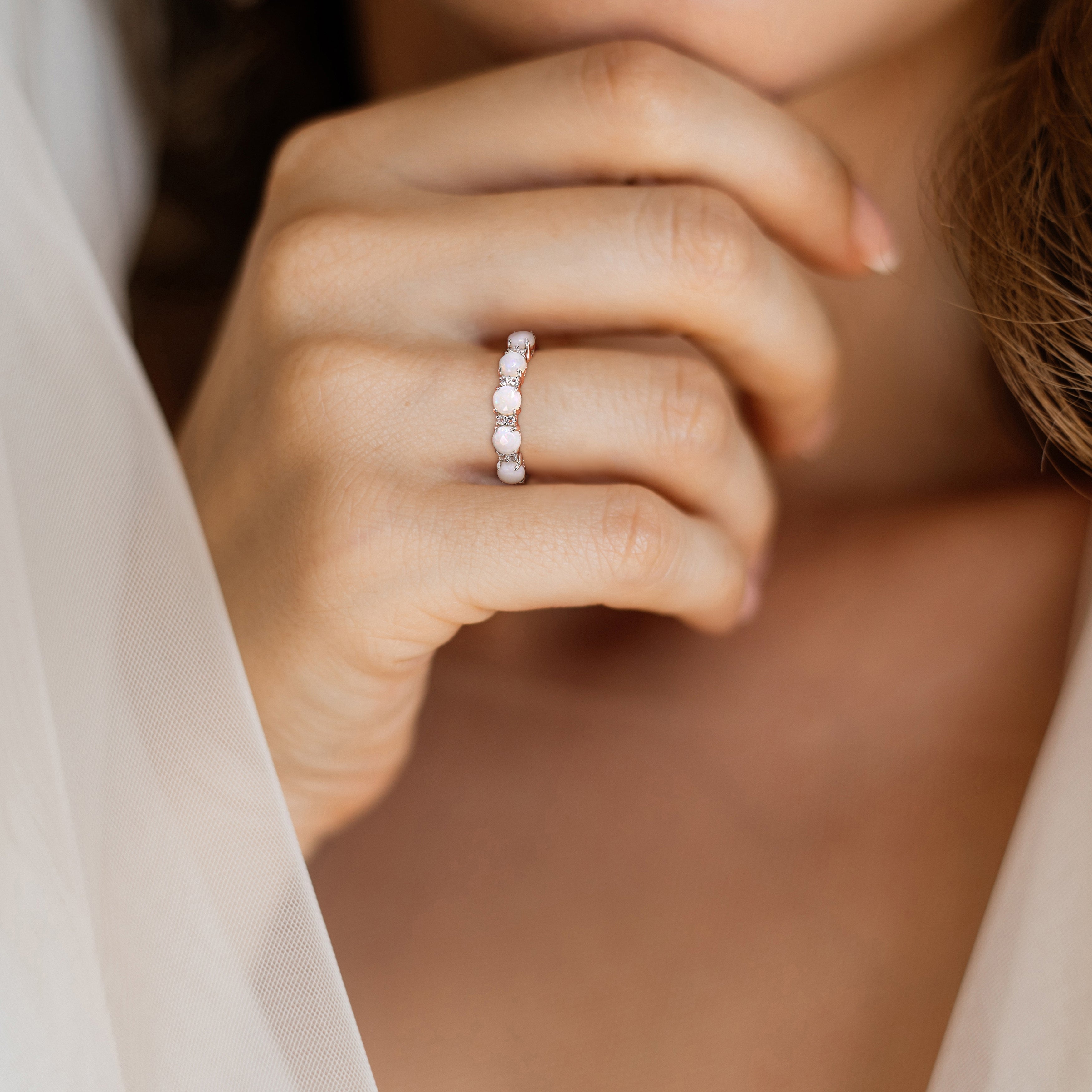 Sterling silver opal and white topaz ring by Delmar, worn on hand