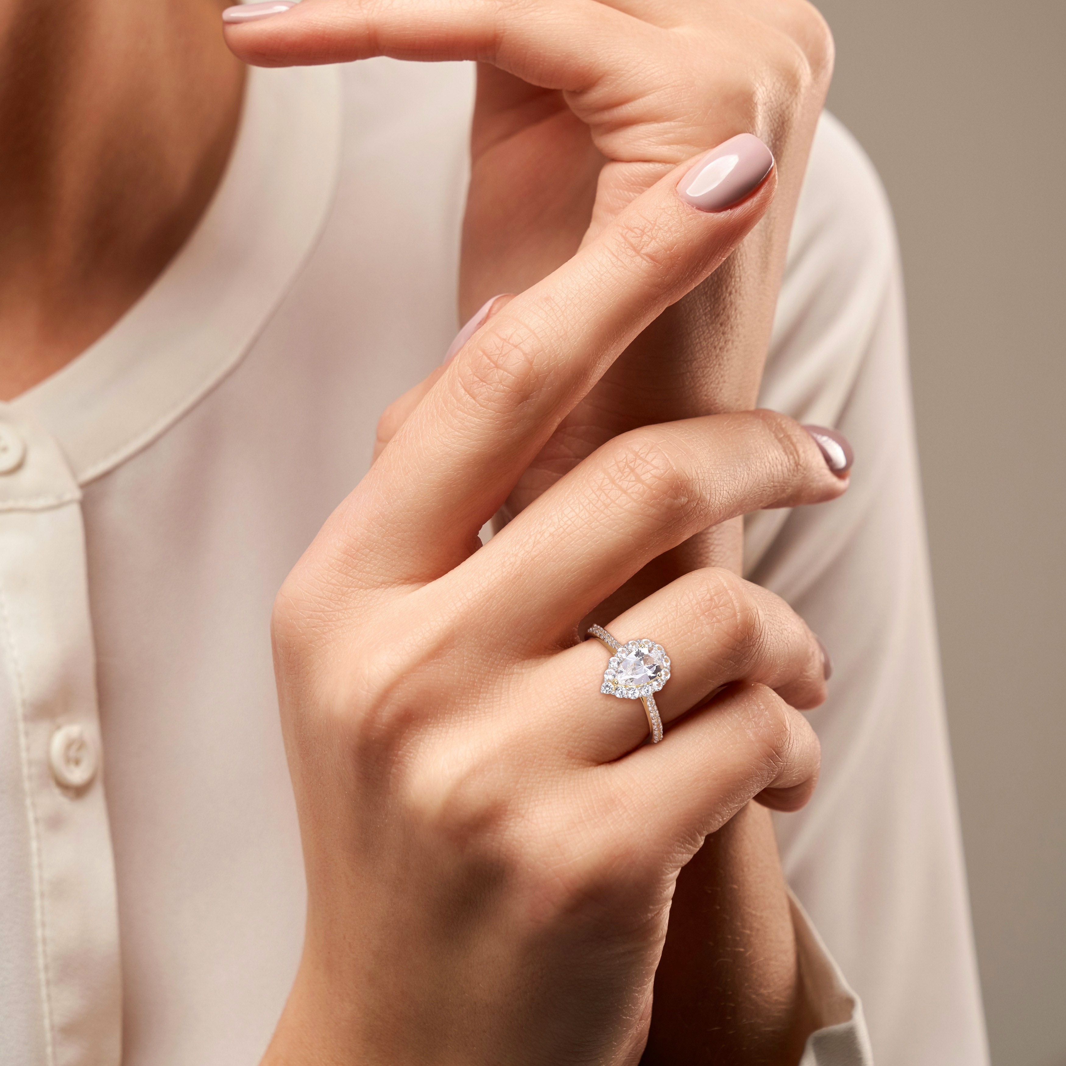 Yellow gold plated teardrop halo ring worn on hand by Lord & Taylor