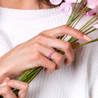 Pink sapphire heart eternity ring in rose-plated sterling silver worn on hand by Lord & Taylor