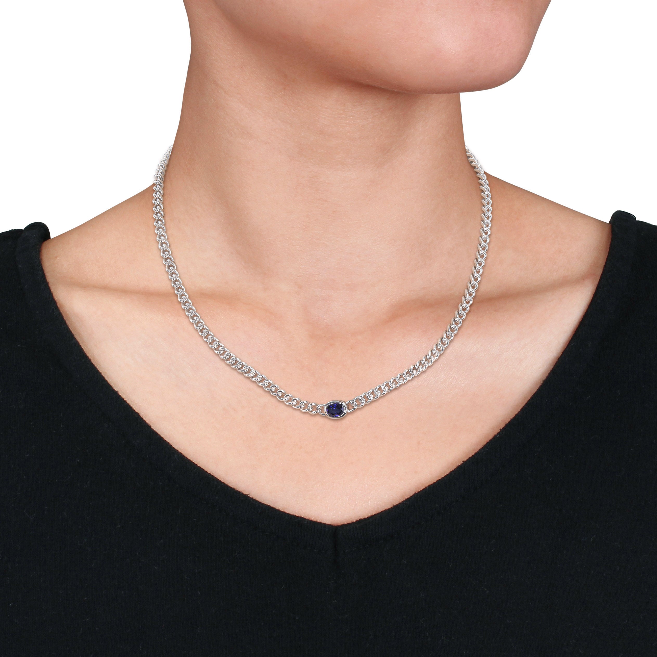 Oval blue sapphire in bezel mount on sterling silver chain, close-up detail