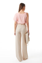 Beige wide-leg trousers detail view showing belt loops and side pockets