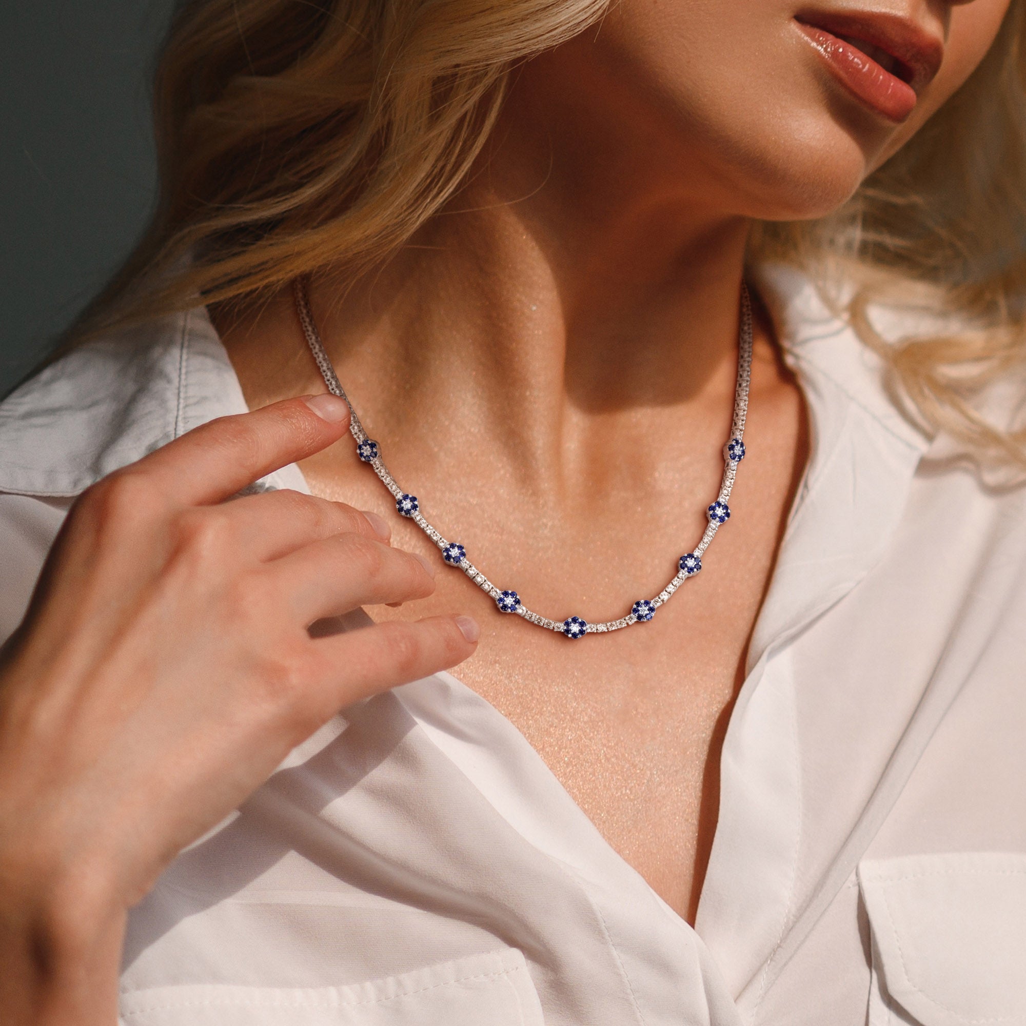 Blue sapphire flower tennis necklace worn on model, lifestyle view
