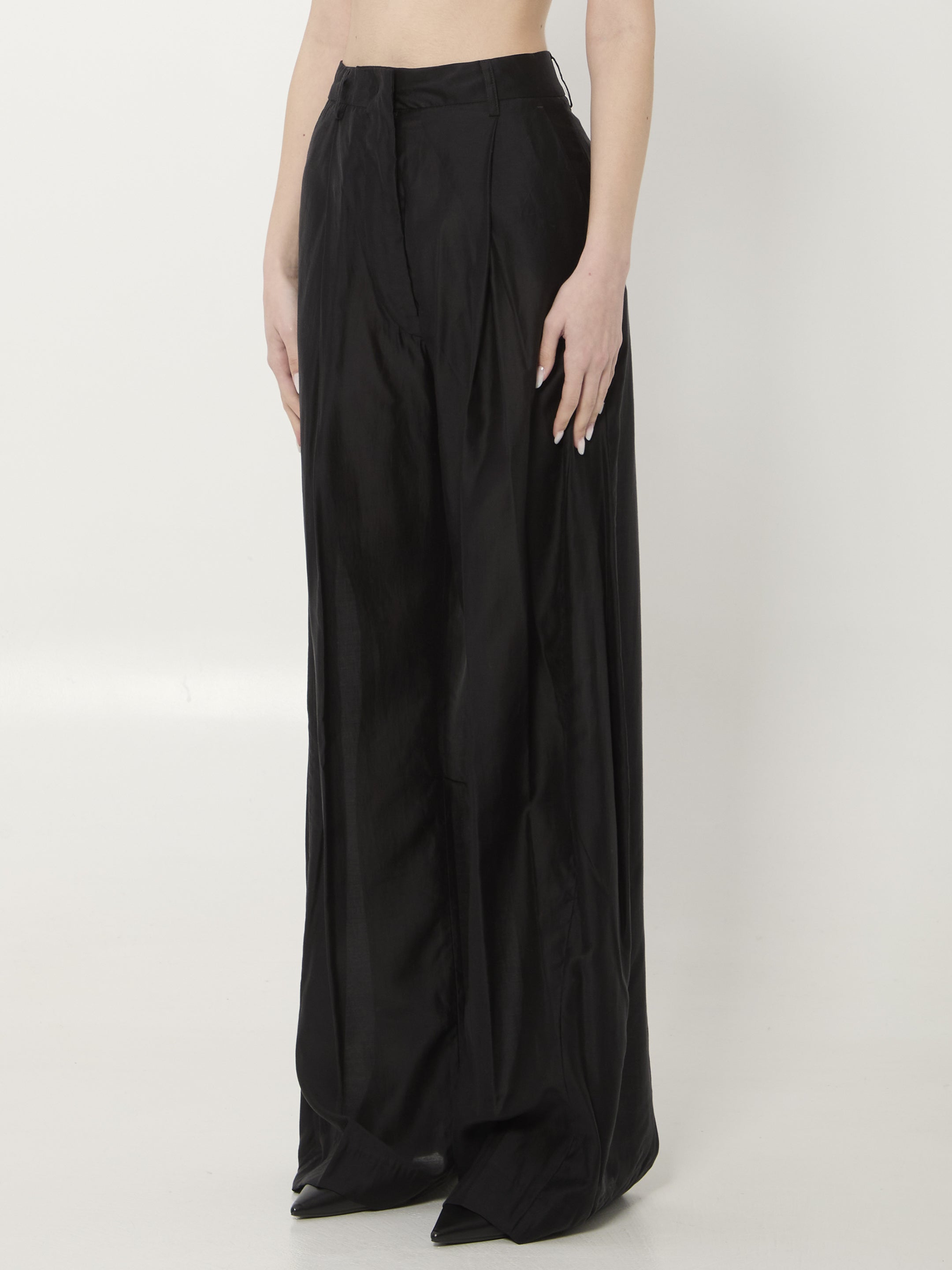 Black muslin Billie trousers by THE LATEST showing side pocket detail and wide leg silhouette
