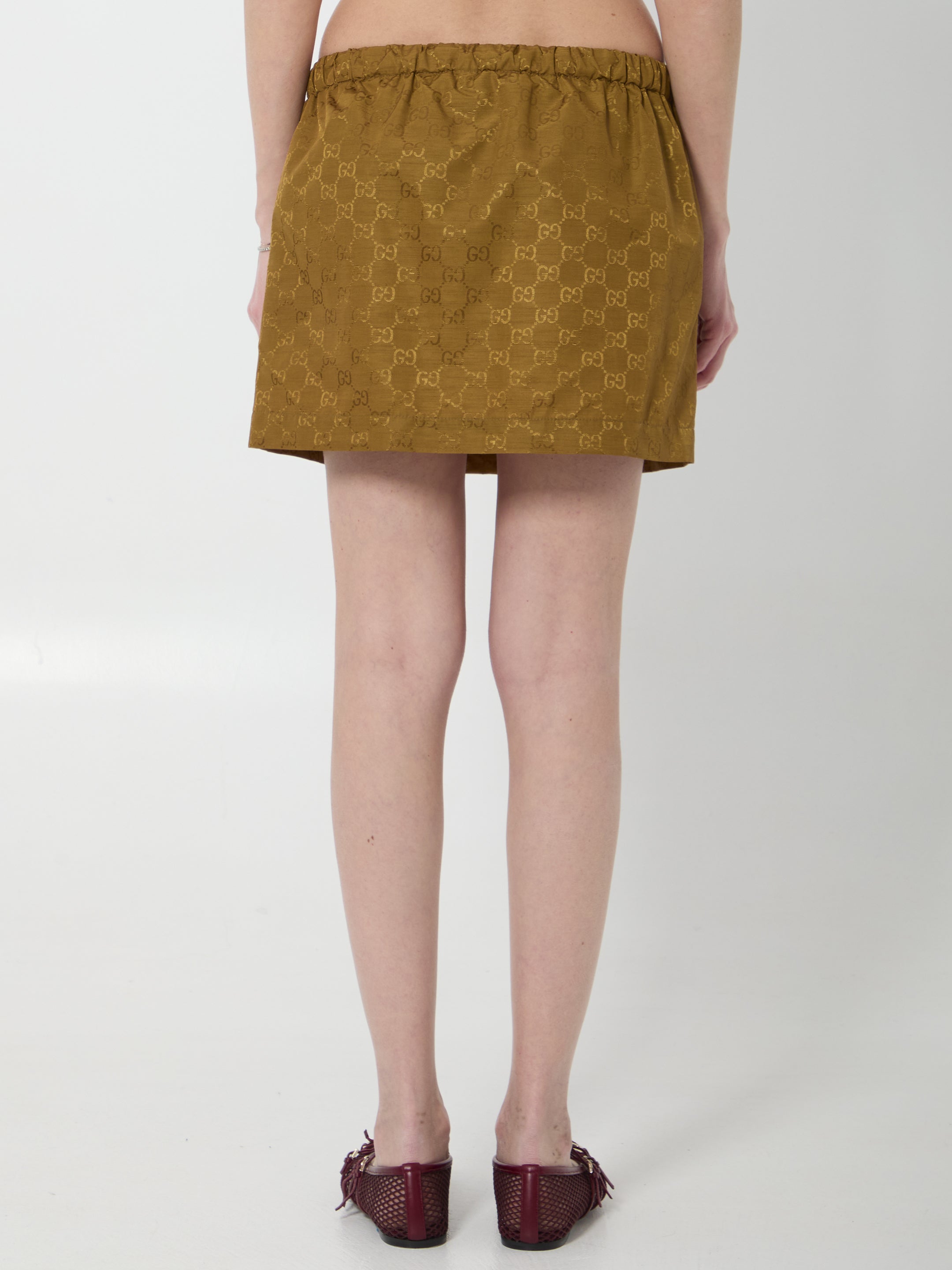 Caramel brown Gucci GG nylon mini skirt, close-up of GG print