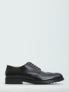 Black patent leather wingtip dress shoes by Tod's, side view
