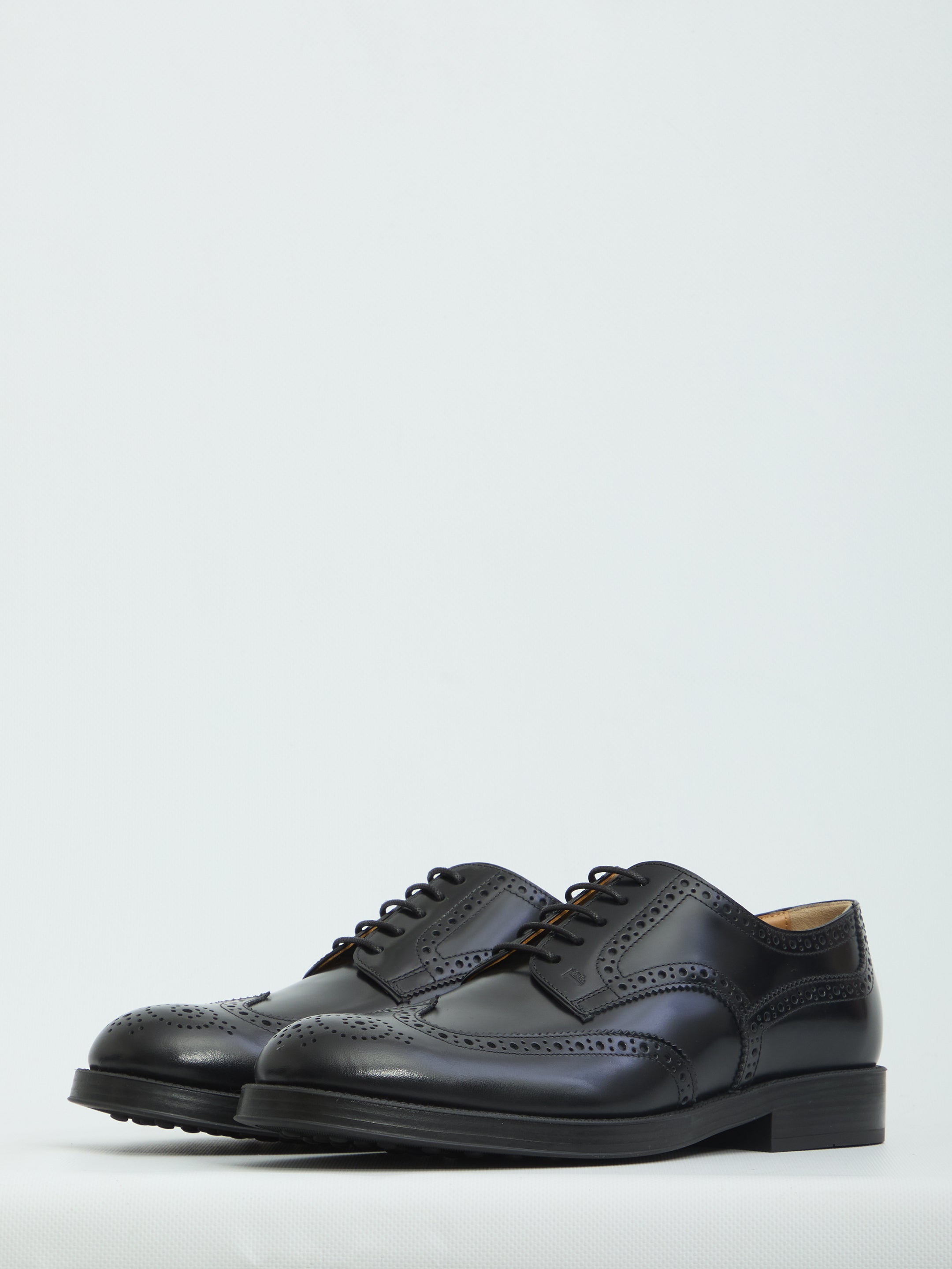 Black patent leather wingtip dress shoes by Tod's, front view