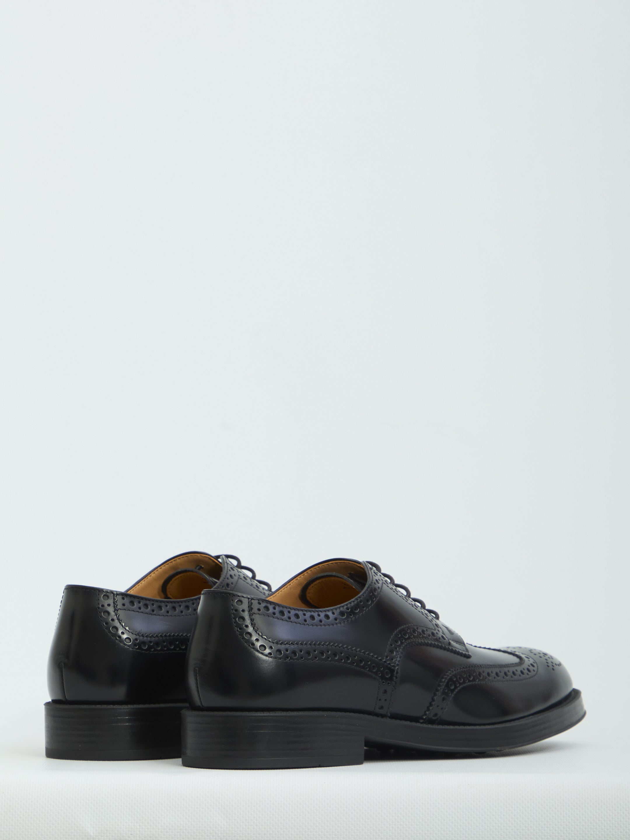 Black patent leather wingtip dress shoes by Tod's, top view showing perforations