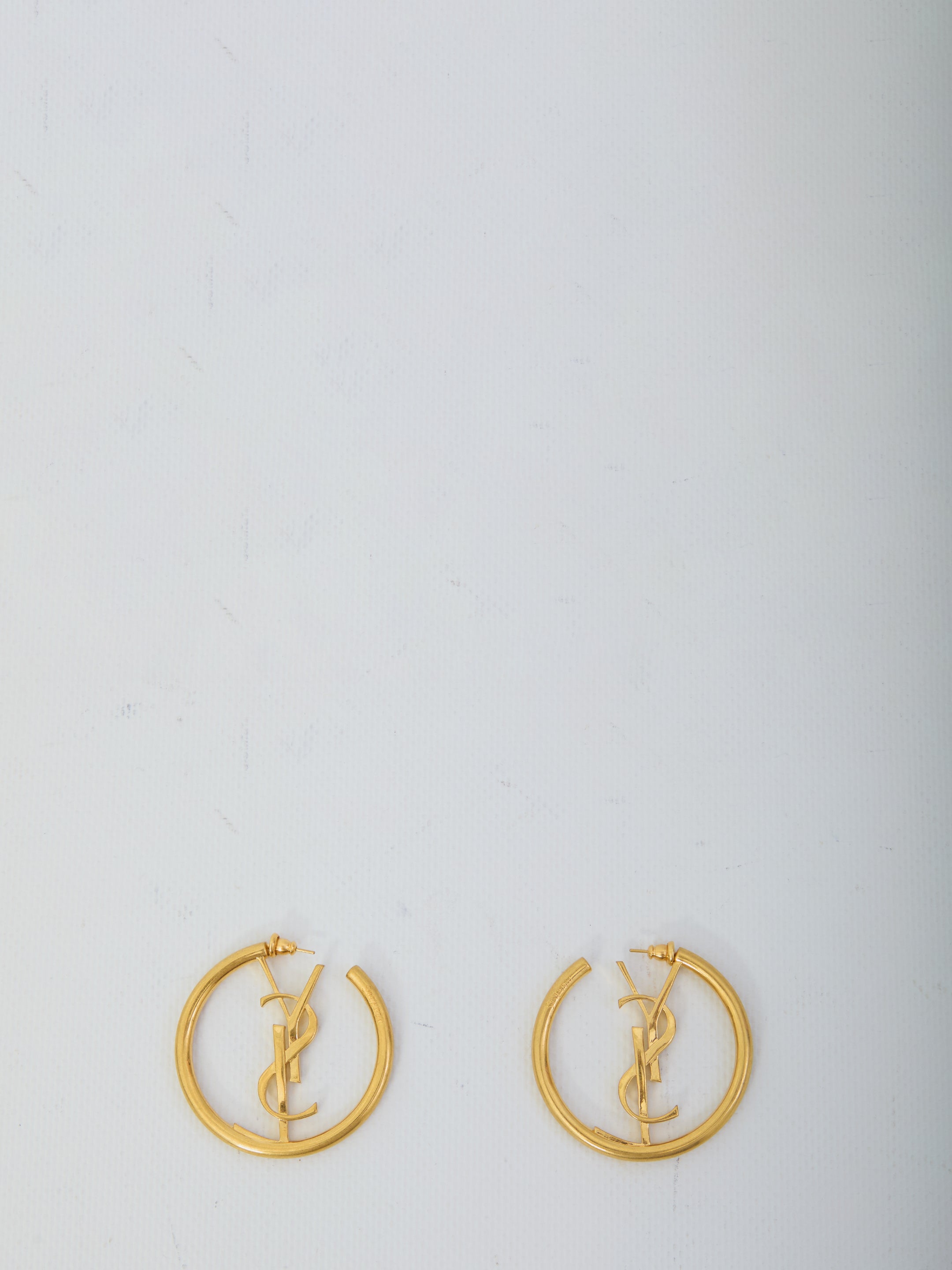 Gold-toned Saint Laurent Cassandre hoop earrings showing butterfly clasp detail