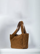 Brown suede Saint Laurent tote bag with Cassandre closure, side view