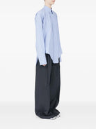 Blue striped cotton shirt by Maison Margiela, side view with button closure