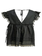 Black GANNI linen blouse showing button closure and tie details, front angle